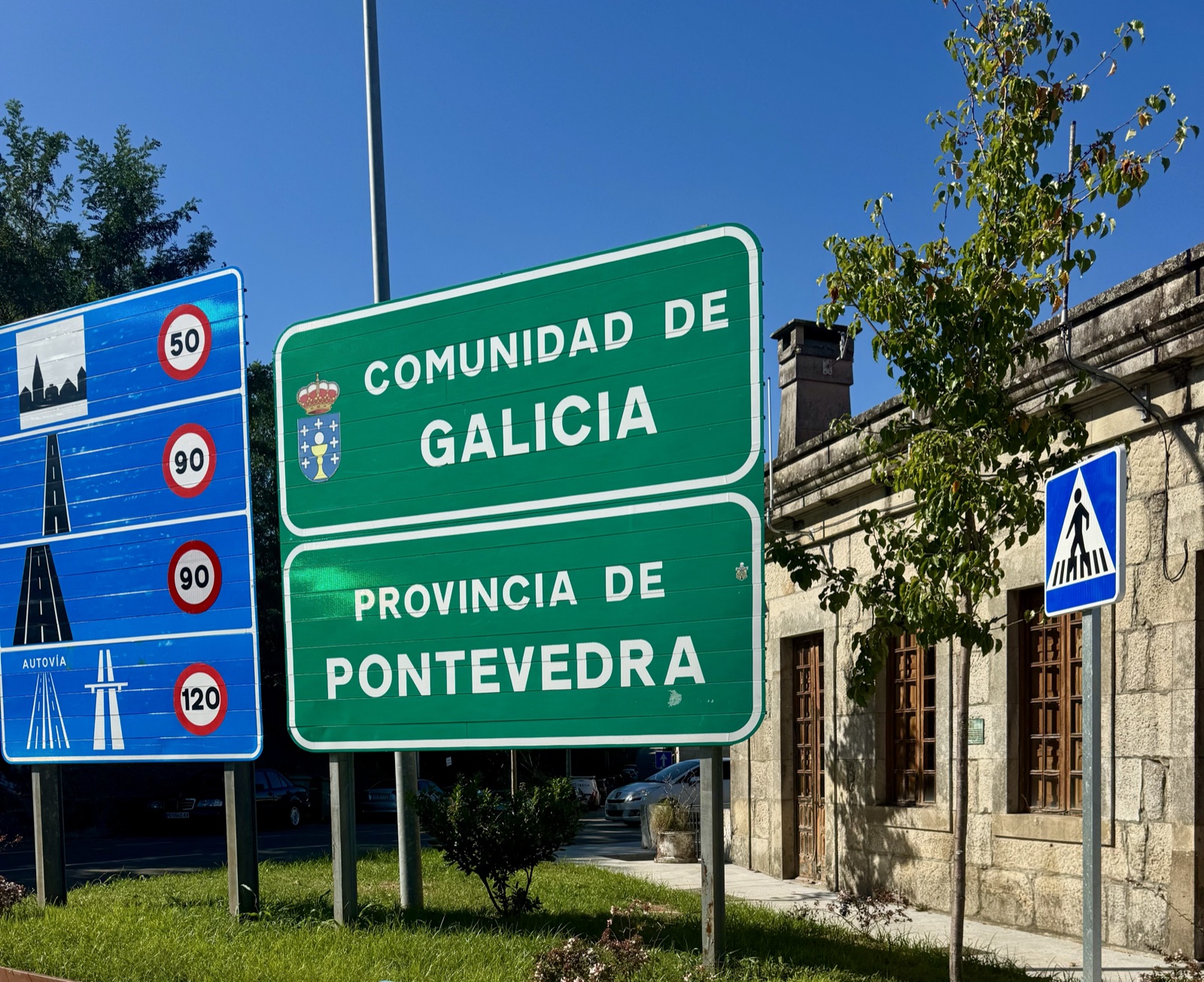 Green road signs reading Comunidad de Galicia and Provincia de Pontevedra beside Spanish speed-limit signs.