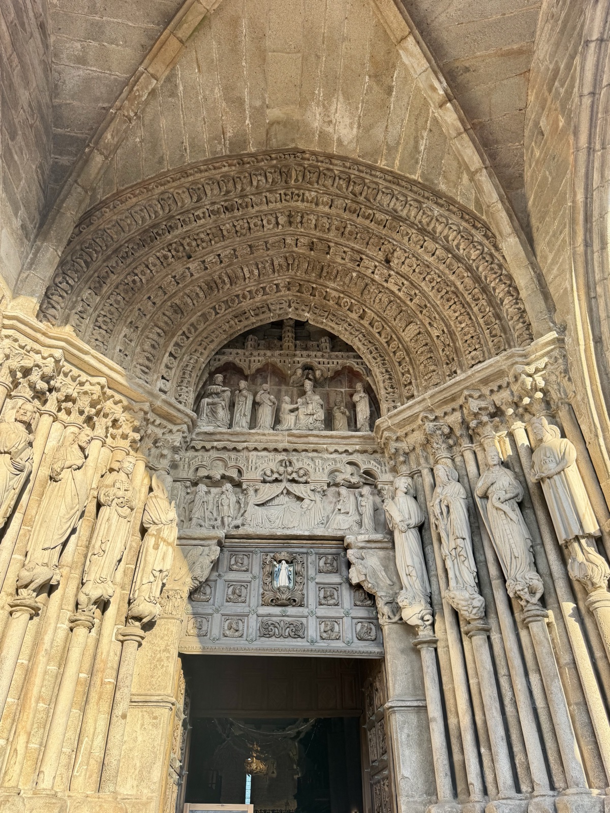 The carved Gothic doorway of Tui Cathedral, rows of stone figures around a pointed arch.