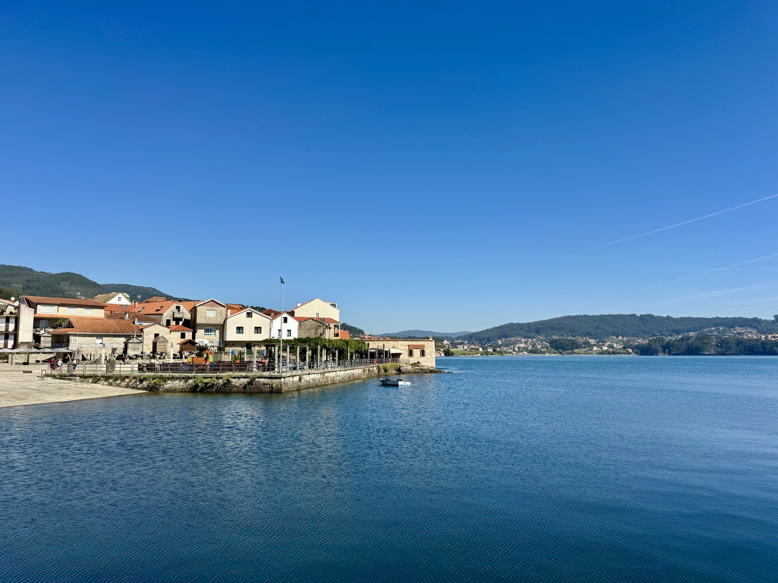 Combarro's waterfront seen across a wide, calm blue bay.