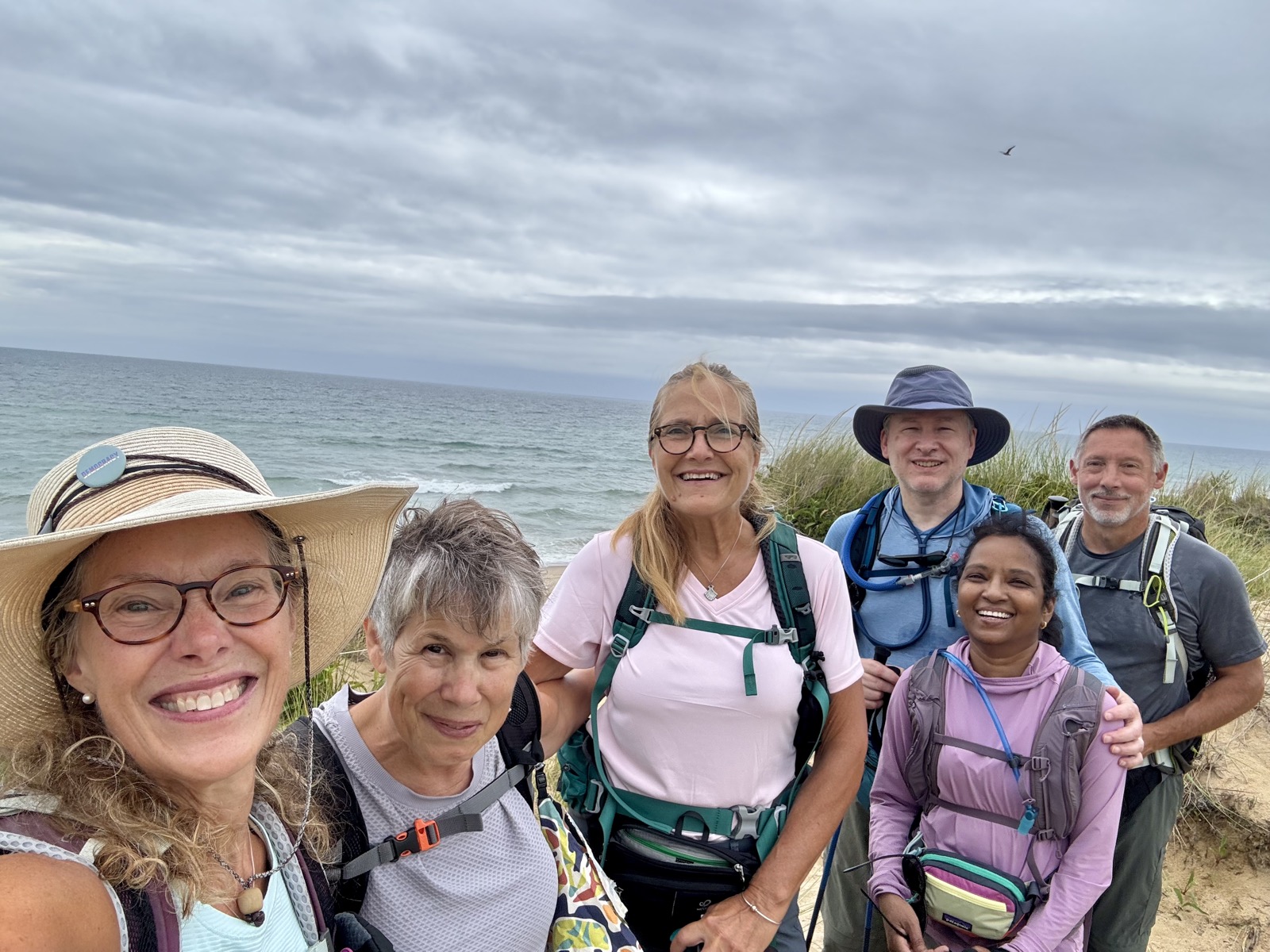 Nancy and five friends pose together on the dunes overlooking the ocean